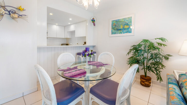 Kitchen view and glass-top dining table in ground floor Villa 3, Grand Cayman Vacation Rental.